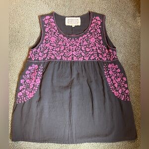 Dark purple top with lighter and brighter purple embroidered flowers.